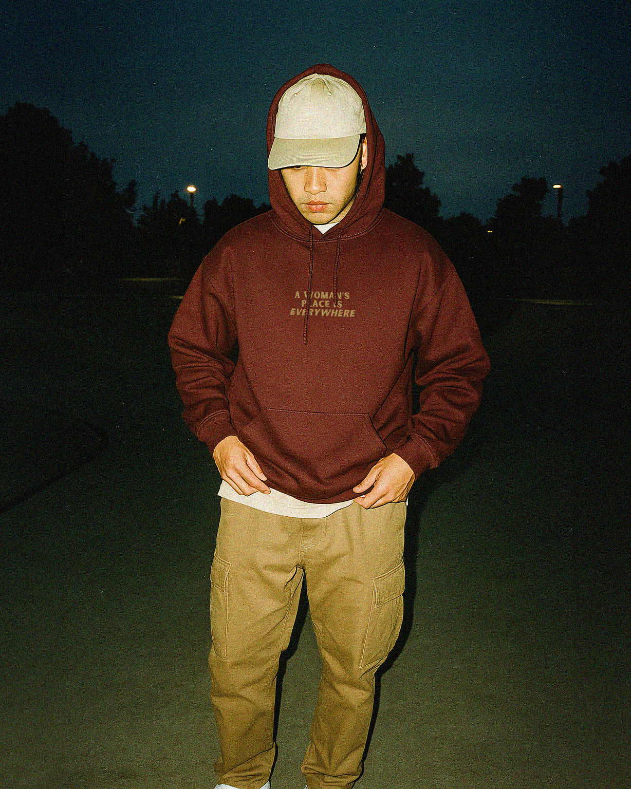 man with brown hair wearing maroon hoodie that says A Woman's Place Is Everywhere